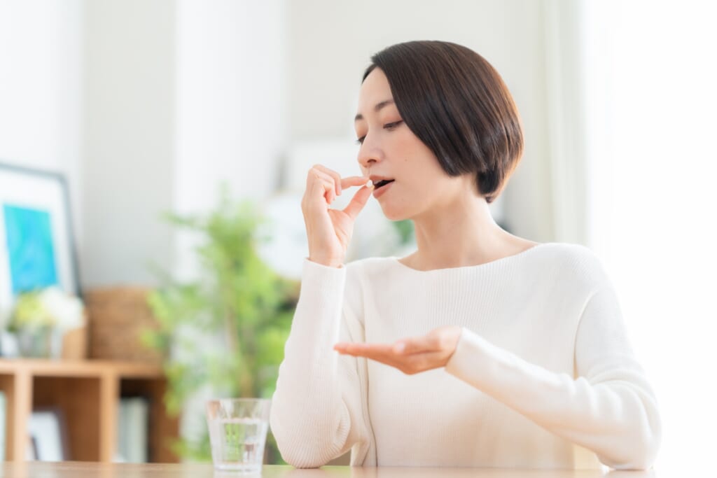 サプリメントを飲む女性