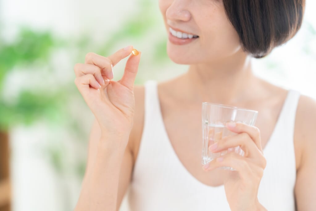サプリメントを飲む女性