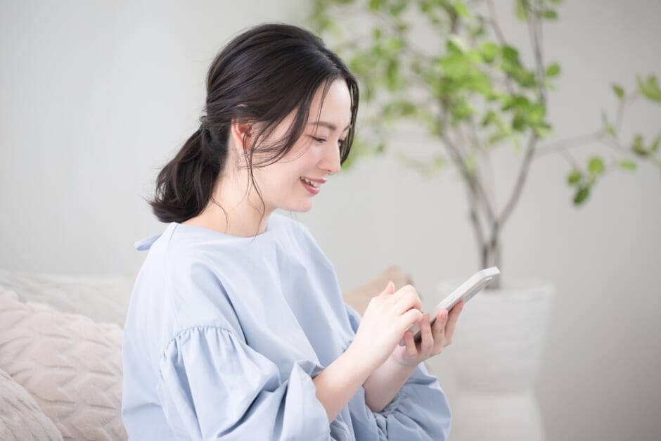 スマートフォンを手に考える日本人女性