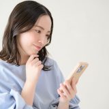 スマートフォンを見ながら考える日本人女性