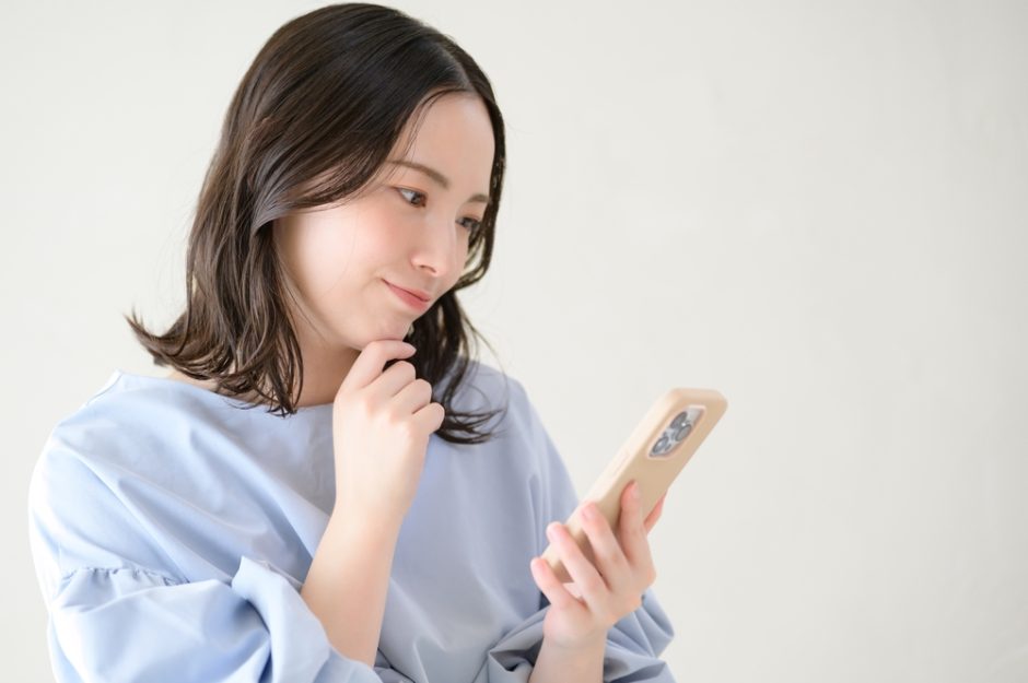 スマートフォンを見ながら考える日本人女性