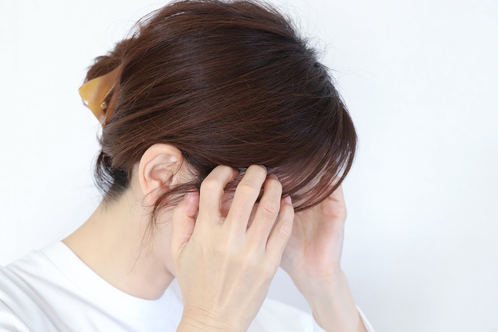 頭に手を添える日本人女性
