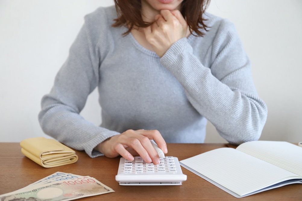 電卓で家計を確認する日本人女性